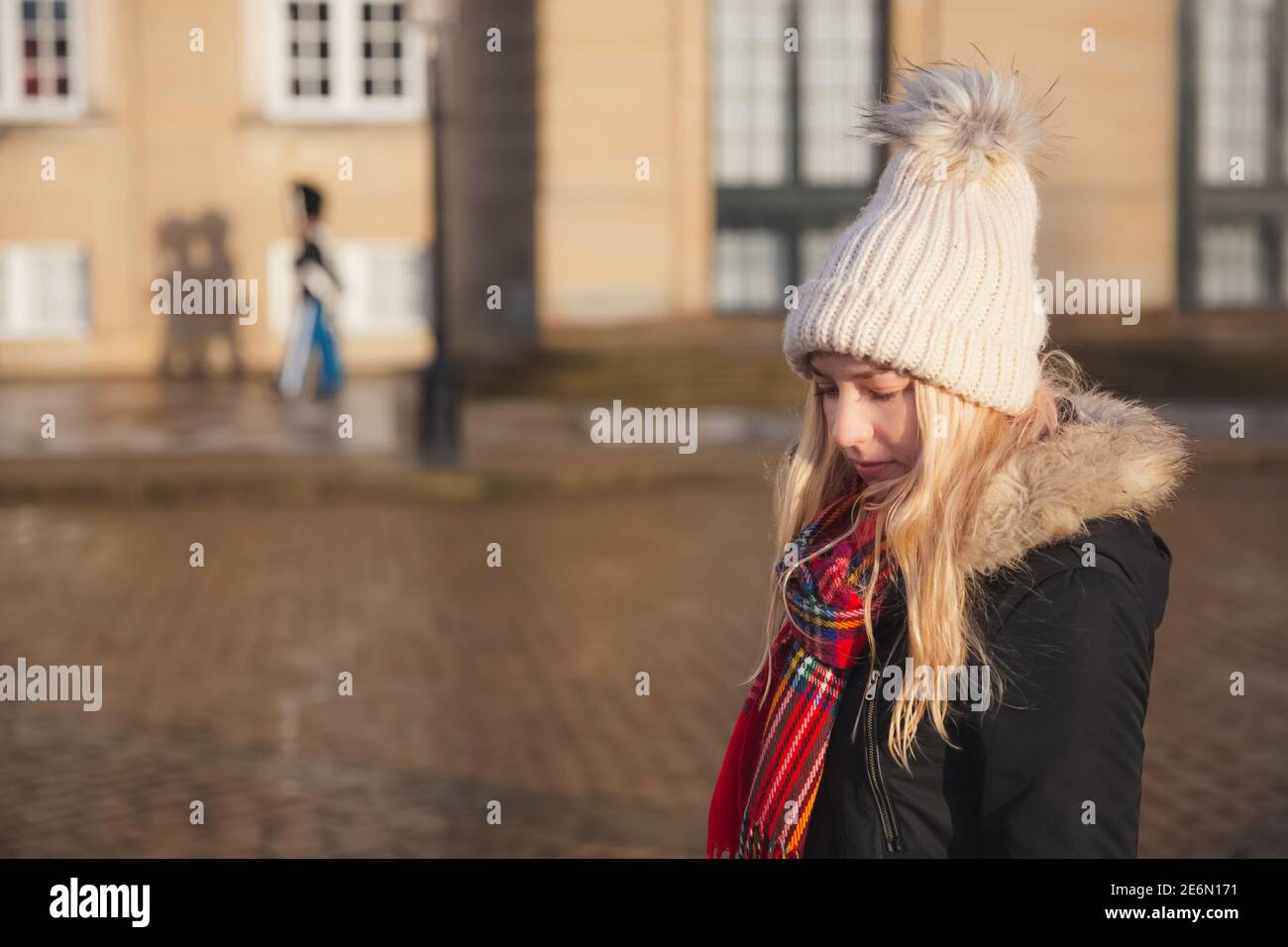 Une jeune femme blonde touriste australienne visitant le Palais Amalienborg, résidence de la famille royale danoise à Copenhague avec l'ombre du Royal LIF Banque D'Images