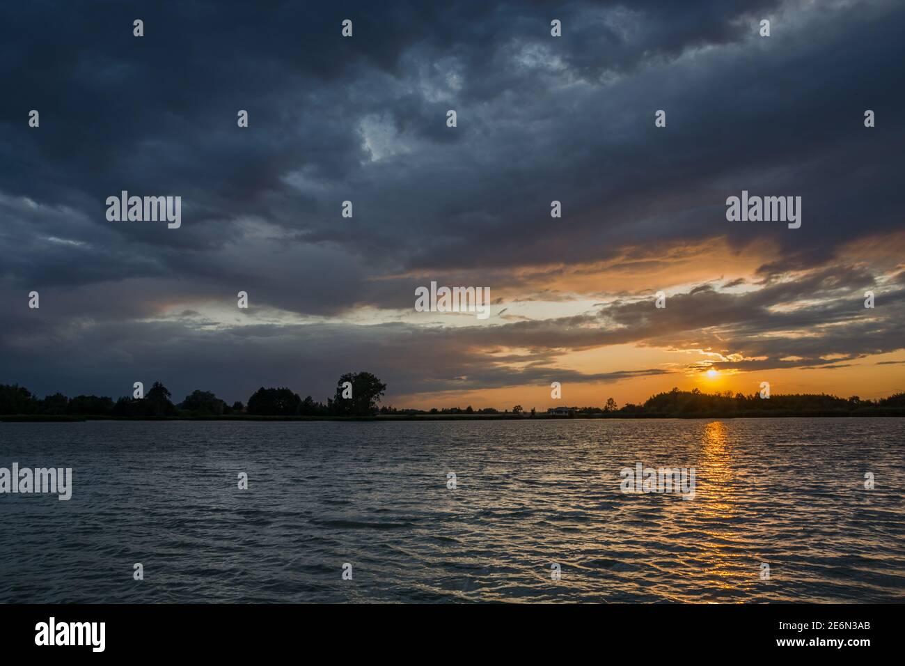 Nuages de tempête sombre sur le lac et coucher de soleil Banque D'Images