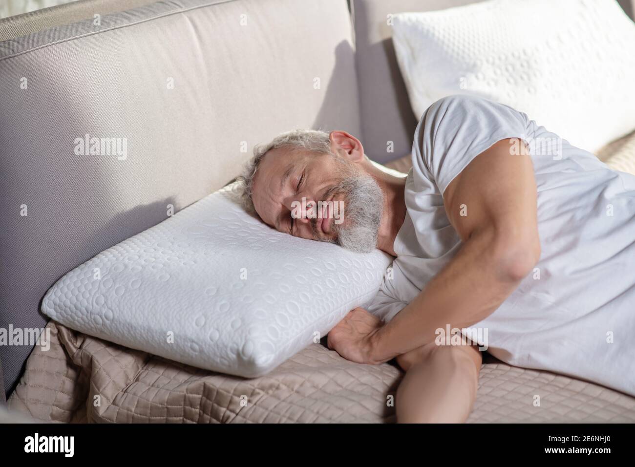 Homme adulte dormant allongé sur le lit Banque D'Images