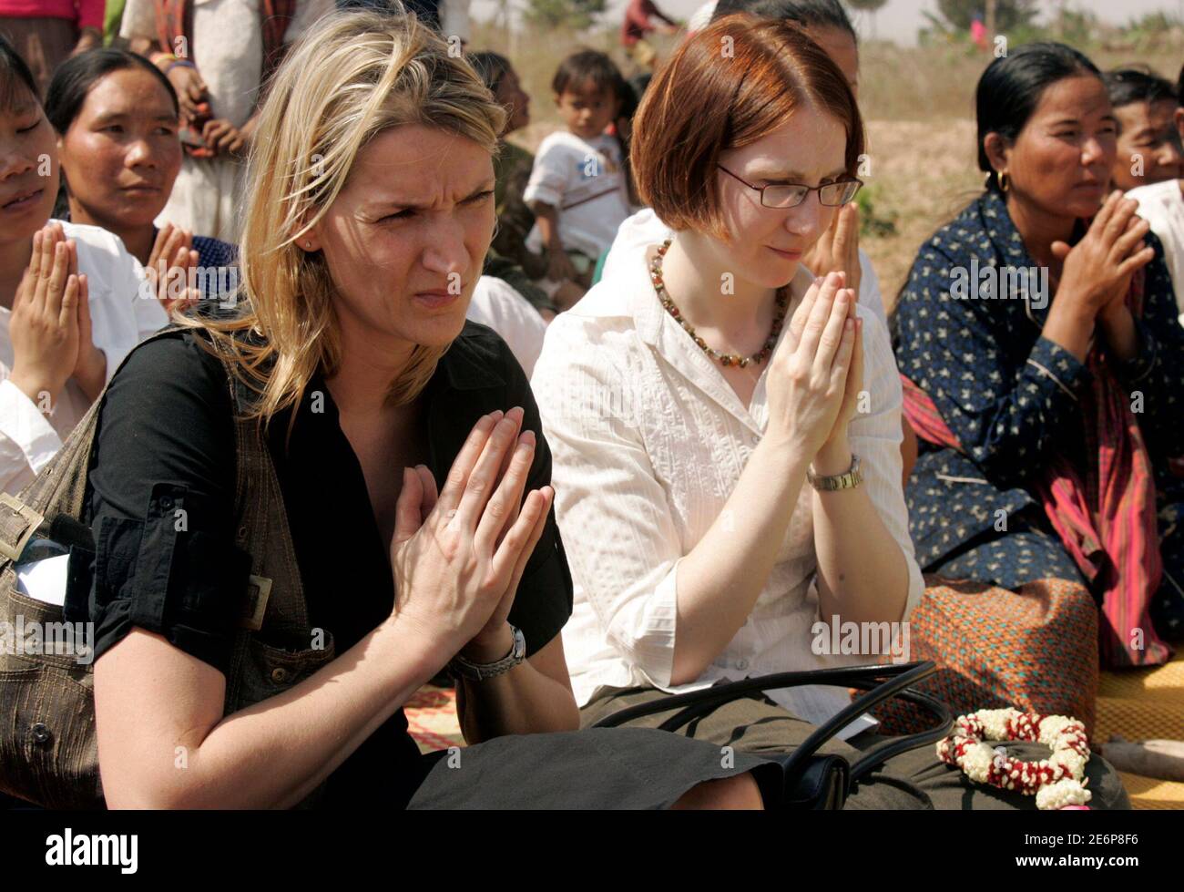 Julia Shand (L), vice consul at the British embassy in Cambodia, and Naomi Viccars, third secretary at the embassy in Cambodia, pray at Sre Chea Choeung commune Kamport province,