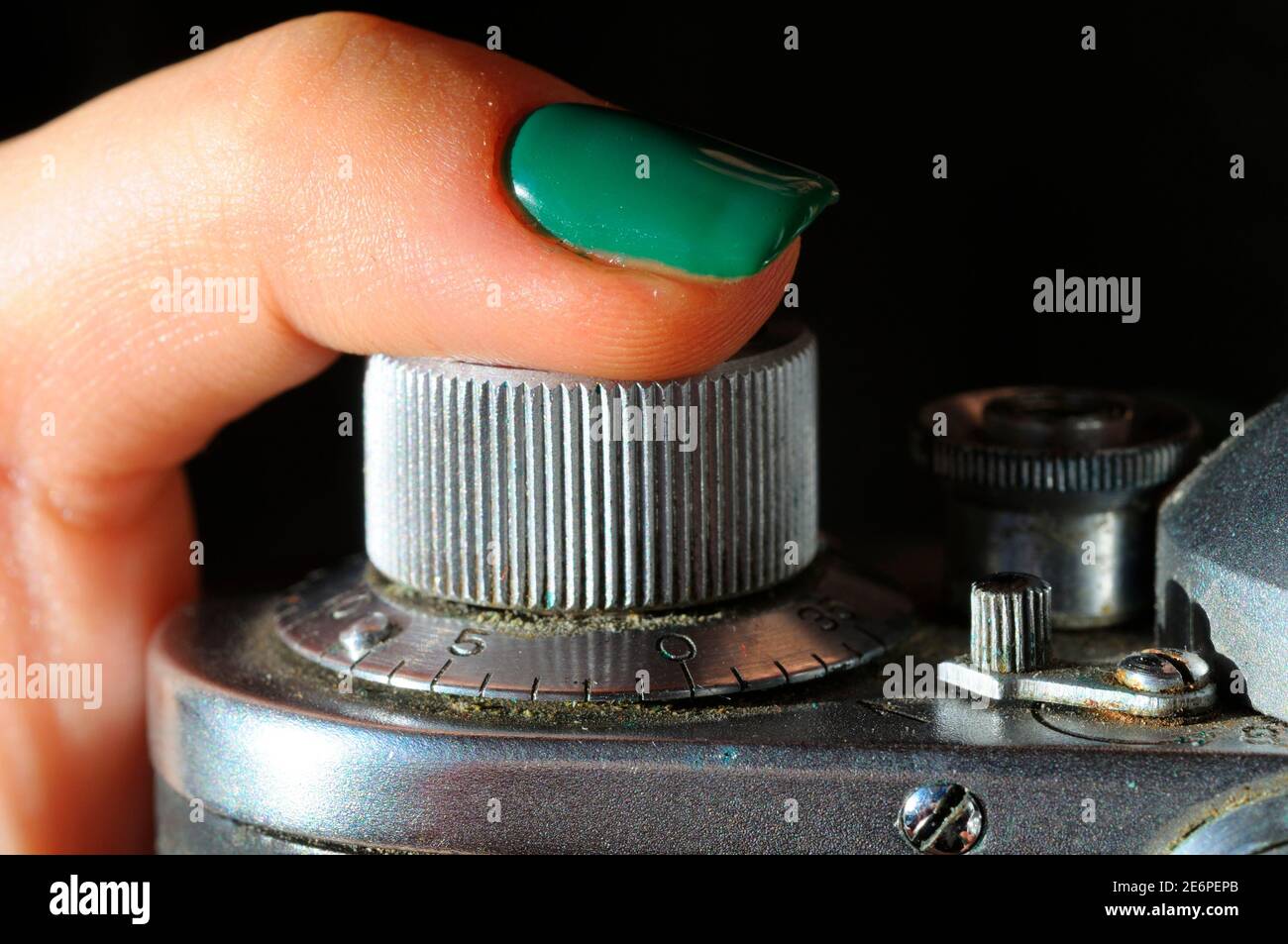 Femme doigt appuyant sur le bouton de déclenchement de l'obturateur d'un ancien appareil photo à film poussiéreux, gros plan Banque D'Images
