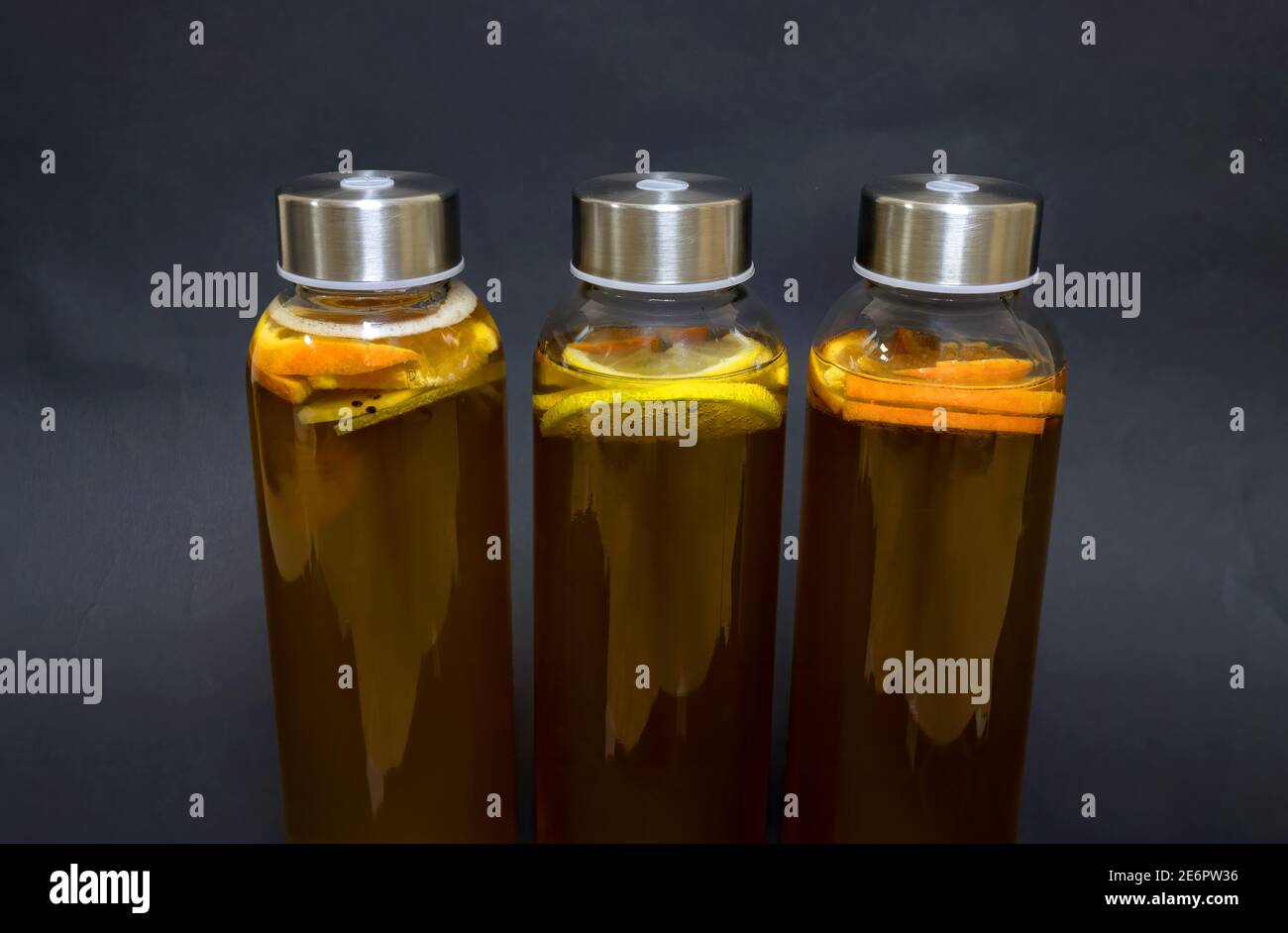 Kombucha filtré et aromatisé avec des saveurs de citron, d'orange et de kiwi isolées sur fond gris Banque D'Images