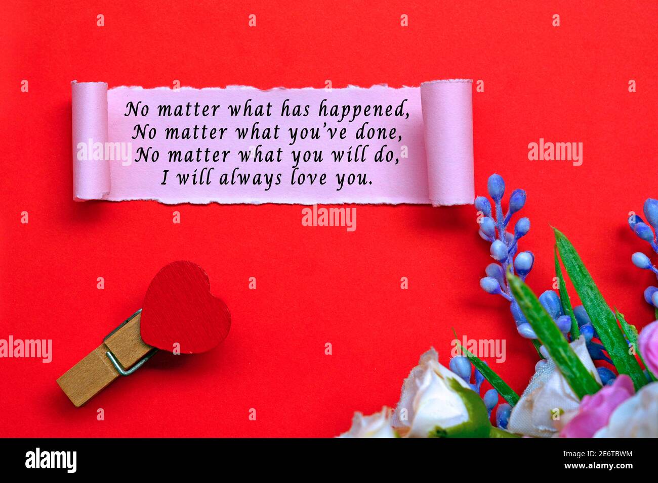 Etiquette de texte sur papier déchiré avec fleurs sur fond rouge. Concept de la Saint-Valentin Banque D'Images