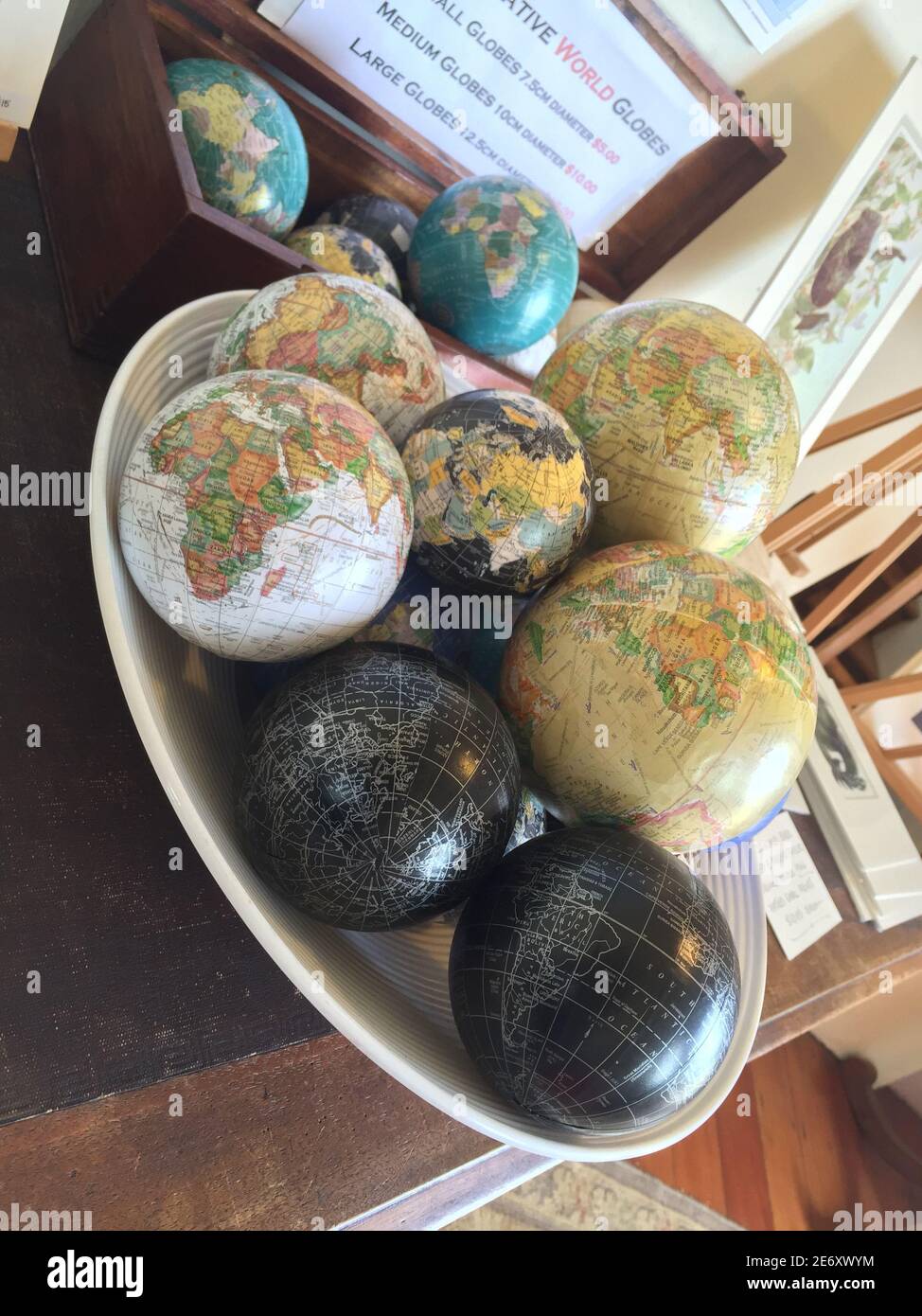 Un cliché vertical de globes de différentes tailles dans un blanc bol sur le bureau Banque D'Images