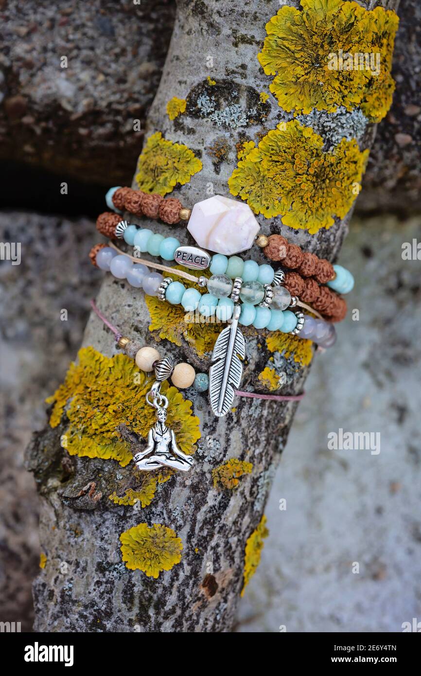 collection de petits bracelets de pierres minérales sur bâton de bois naturel arrière-plan Banque D'Images