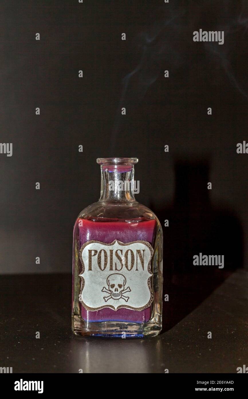 Concept de chose toxique. Flacon transparent avec liquide violet simulant le poison. L'étiquette indique poison avec un crâne et deux tibias Banque D'Images