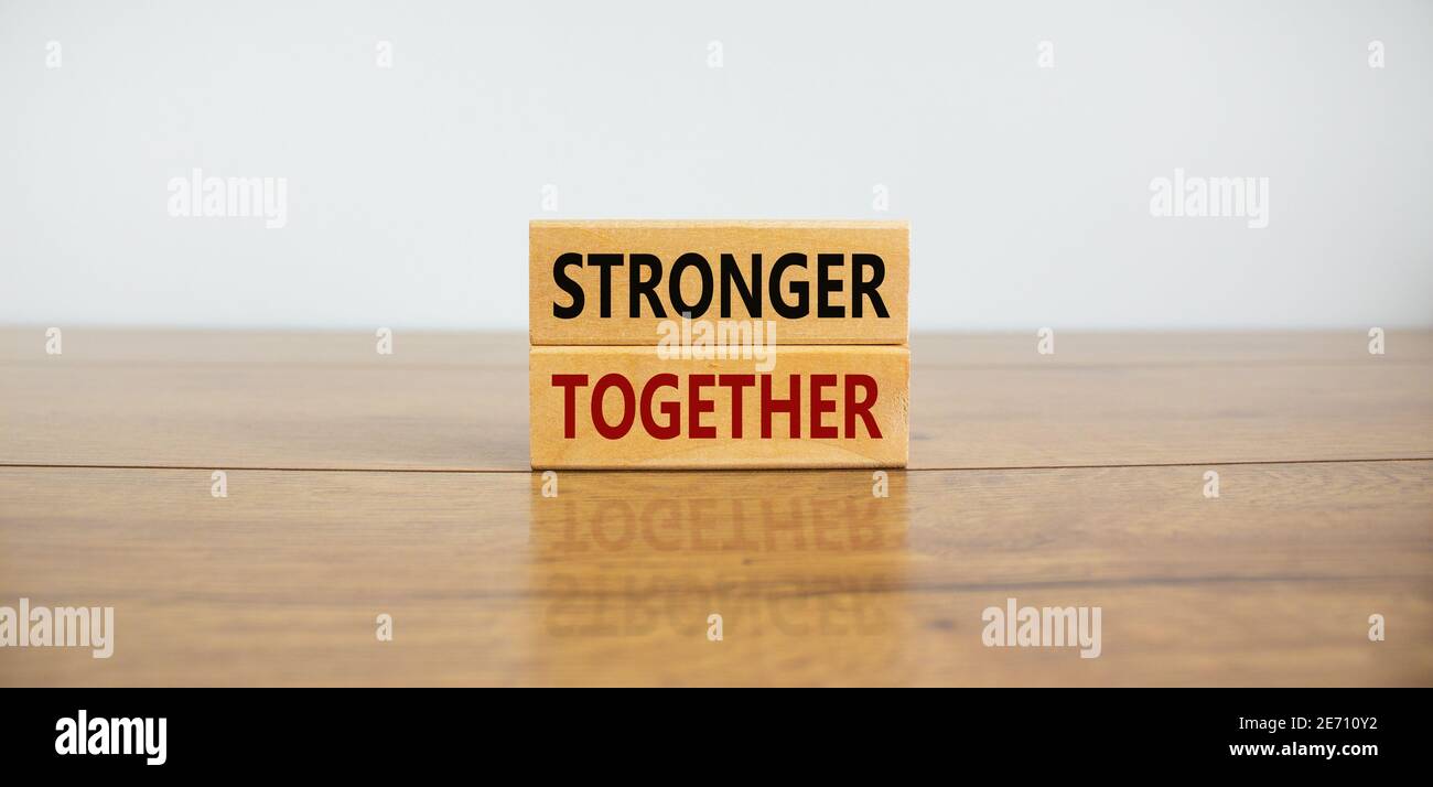 Symbole « plus fort ensemble ». Concept mots "ensemble" sur des blocs de bois sur une belle table en bois, fond blanc. Entreprise, motivation et Banque D'Images