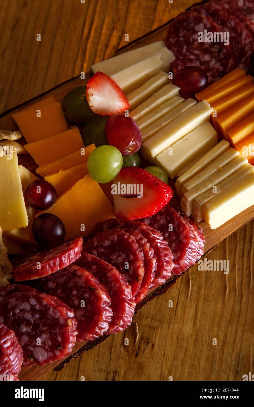 Carte de charcuterie italienne avec biscuits secs au fromage et salami planche en bois avec bord d'écorce brut Banque D'Images