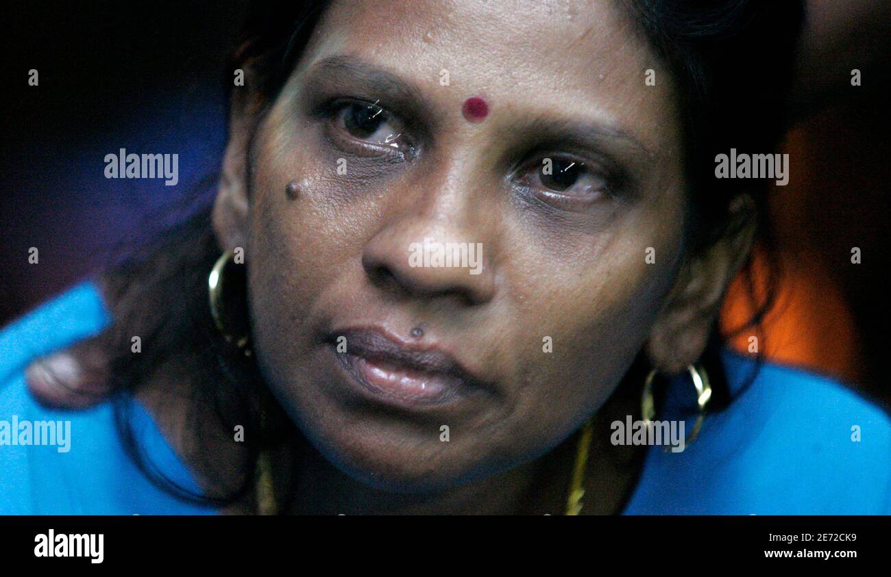 Kanagam Rama, the mother of the 12-year-old girl Diryasree Vasudeyan, who  is missing after a suspension bridge collapsed, holds her tears as she  waits for rescuers searching for her daughter, at her