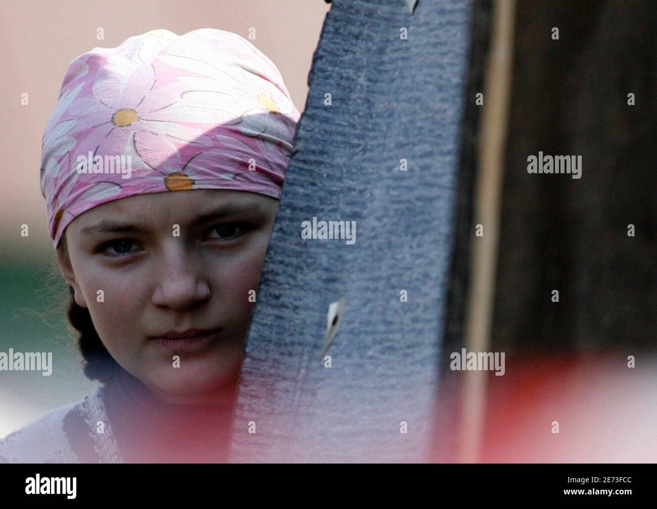 A girl who belongs to a doomsday cult stands outside the house of the  group's leader in the village of Nikolskoye in the Penza region April 4,  2008. A Russian cult leader