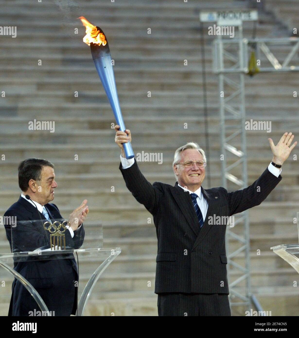 Head of the Turin Winter Olympics Valentino Castellani (R) waves the Olympic  torch handed over by President of the Greek Olympic Committee Minos  Kyriakou inside Athens' Panathinaiko stadium December 6, 2005. The
