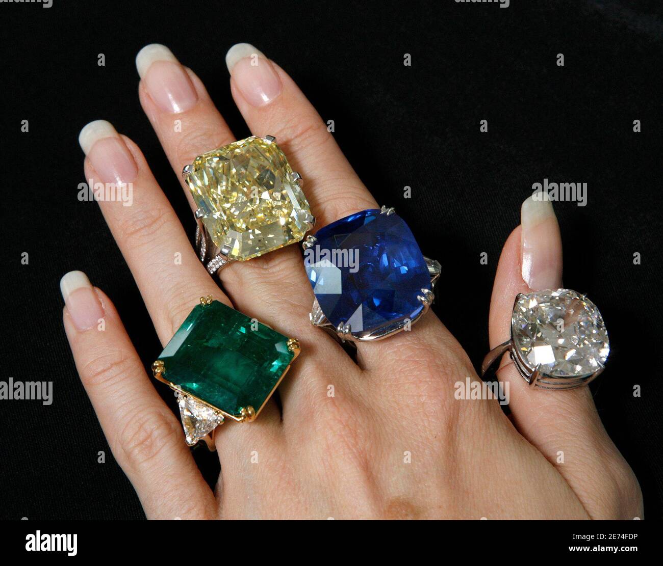 Helen Molesworth, spécialiste des bijoux de Christie, présente un anneau d'émeraude et de diamant (L) estimé à 600,000 $ - à 800,000 $; un anneau de diamant de couleur (2L) estimé à 1,400,000 $ - à 1,650,000 $; Un anneau saphir (2R) estimé à 300,000 $ - à 410,000 $ et un anneau diamant simple pierre (R) estimé à 600,000 $ - à 680,000 $ pendant un aperçu de vente aux enchères à Genève le 11 mai 2007. Les bijoux seront vendus lors d'une vente à Genève le 17 mai 2007. REUTERS/Denis Balibouse (SUISSE) Banque D'Images