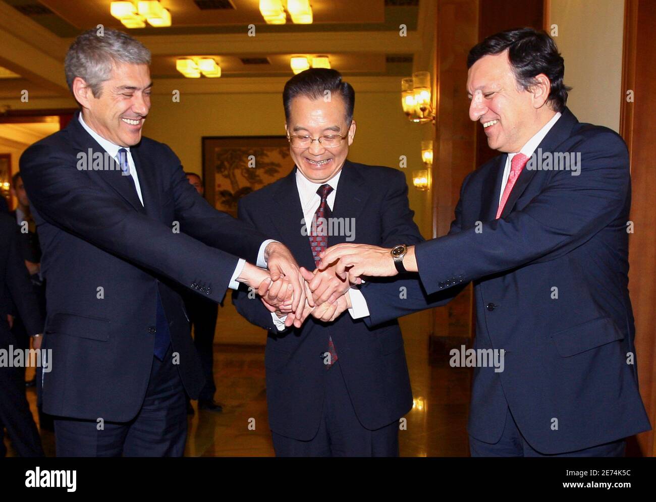 Portugal's Prime Minister and European Union President Jose Socrates (L) and European Commission President Jose Manuel Barroso (R) laugh as China's Premier Wen Jiabao (C) holds their hands together before their meeting in the Great Hall of the People in Beijing November 28, 2007. REUTERS/David Gray (CHINA) Banque D'Images