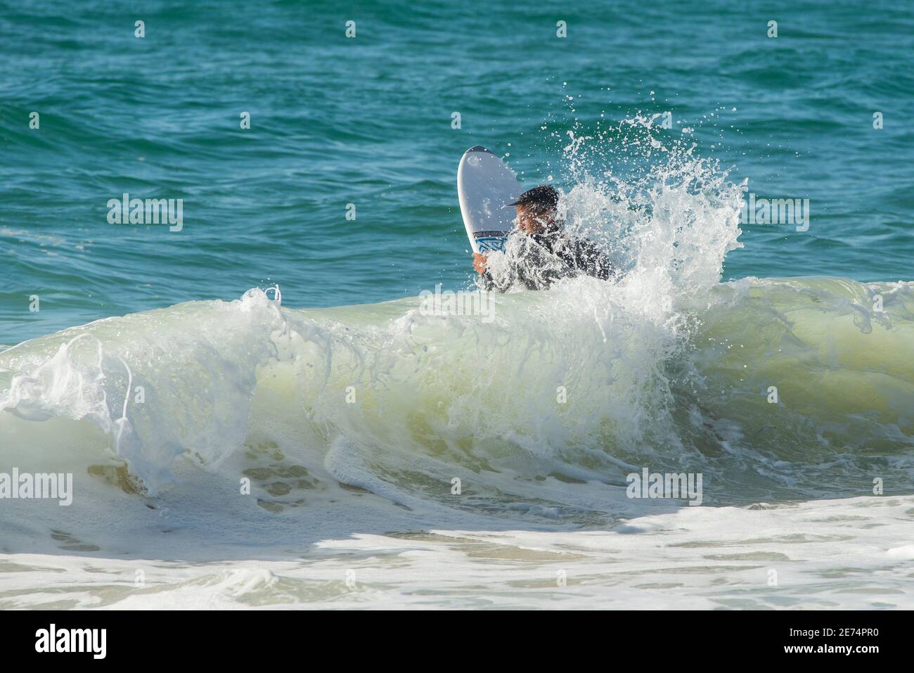 Un jeune garçon surfant dans l'océan Atlantique à Biscarrosse. Biscarrosse Plage est une destination de surf importante sur l'océan Atlantique en France Banque D'Images