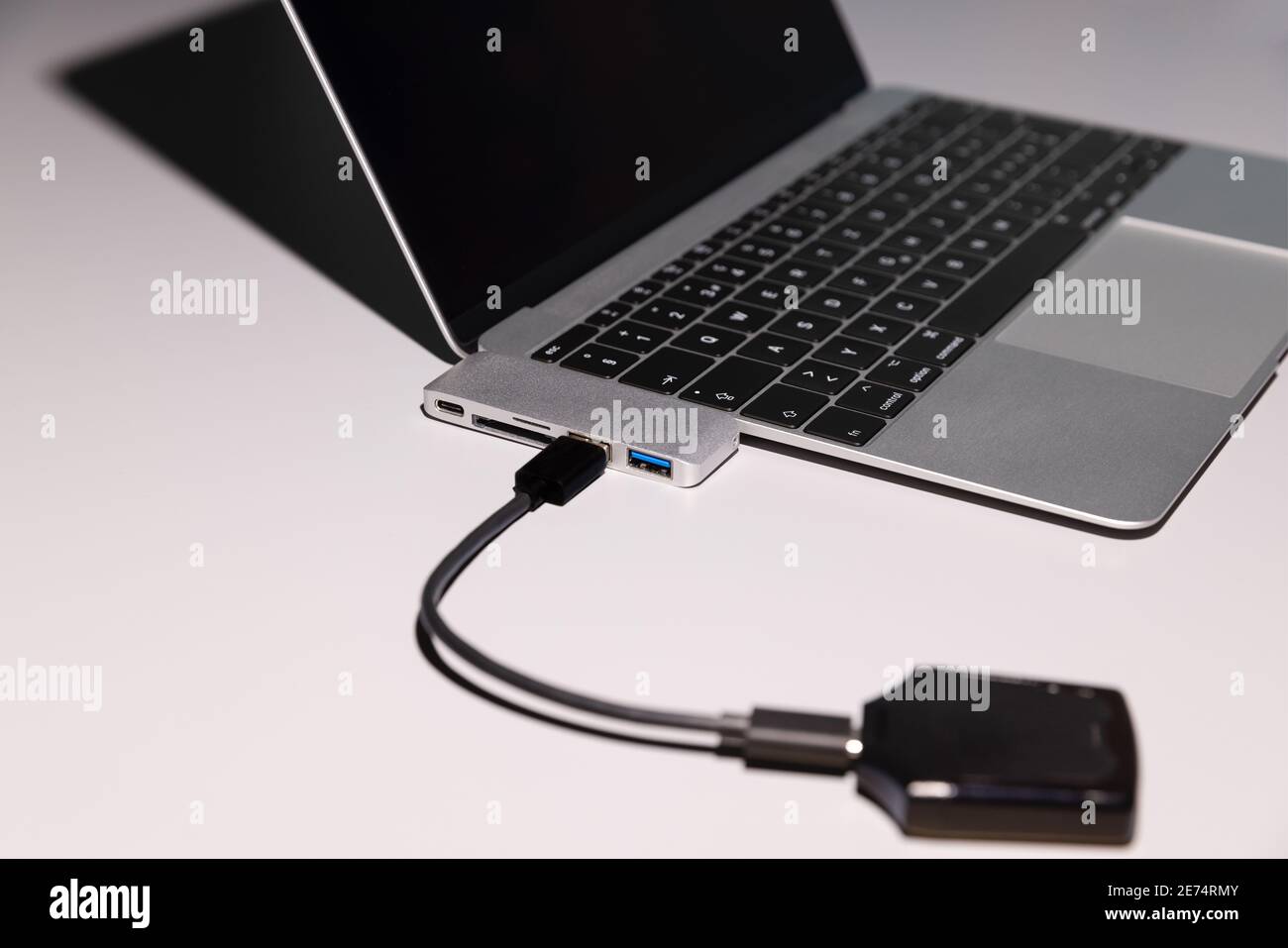 Ordinateur avec périphérique, l'image est avec intention fortement concentrée sur l'adaptateur, ordinateur portable ouvert avec usb-c à usb A, C, chariot sd, micro Banque D'Images