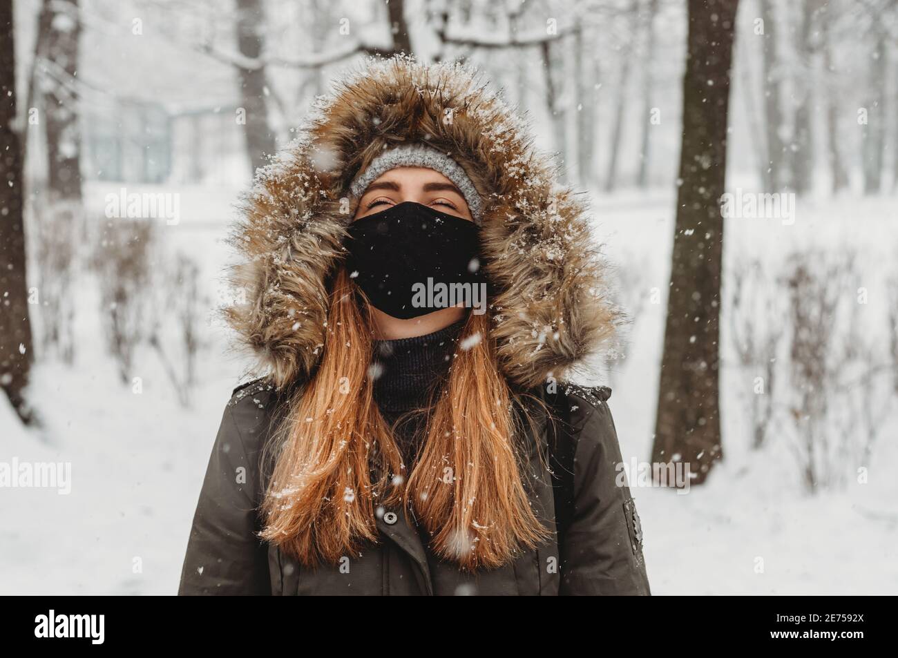 femme en hiver avec des vêtements de masque facial appréciant la neige Banque D'Images