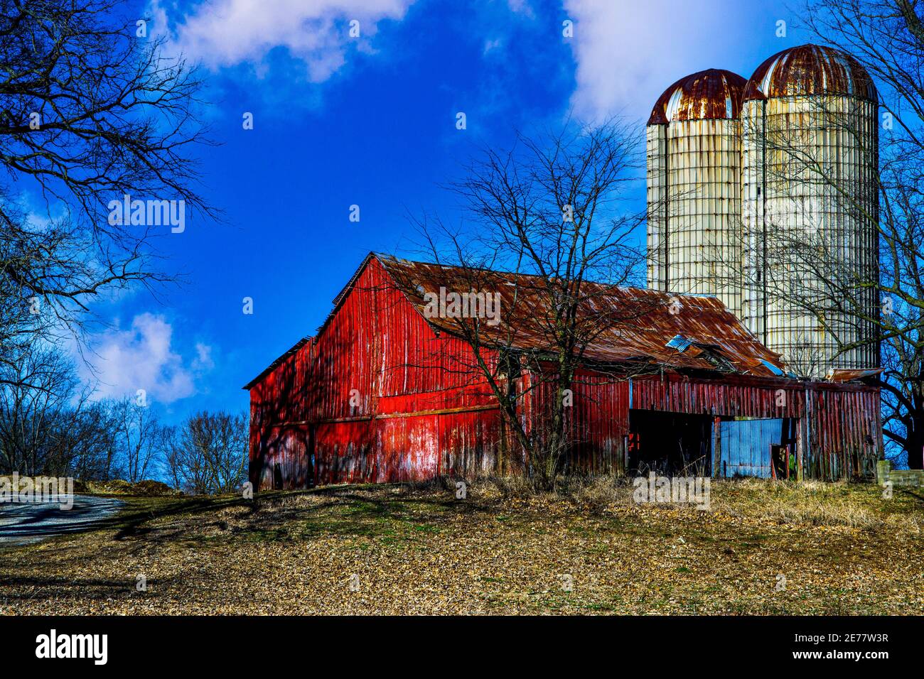 Ancienne grange rouge avec silo dominant. Banque D'Images