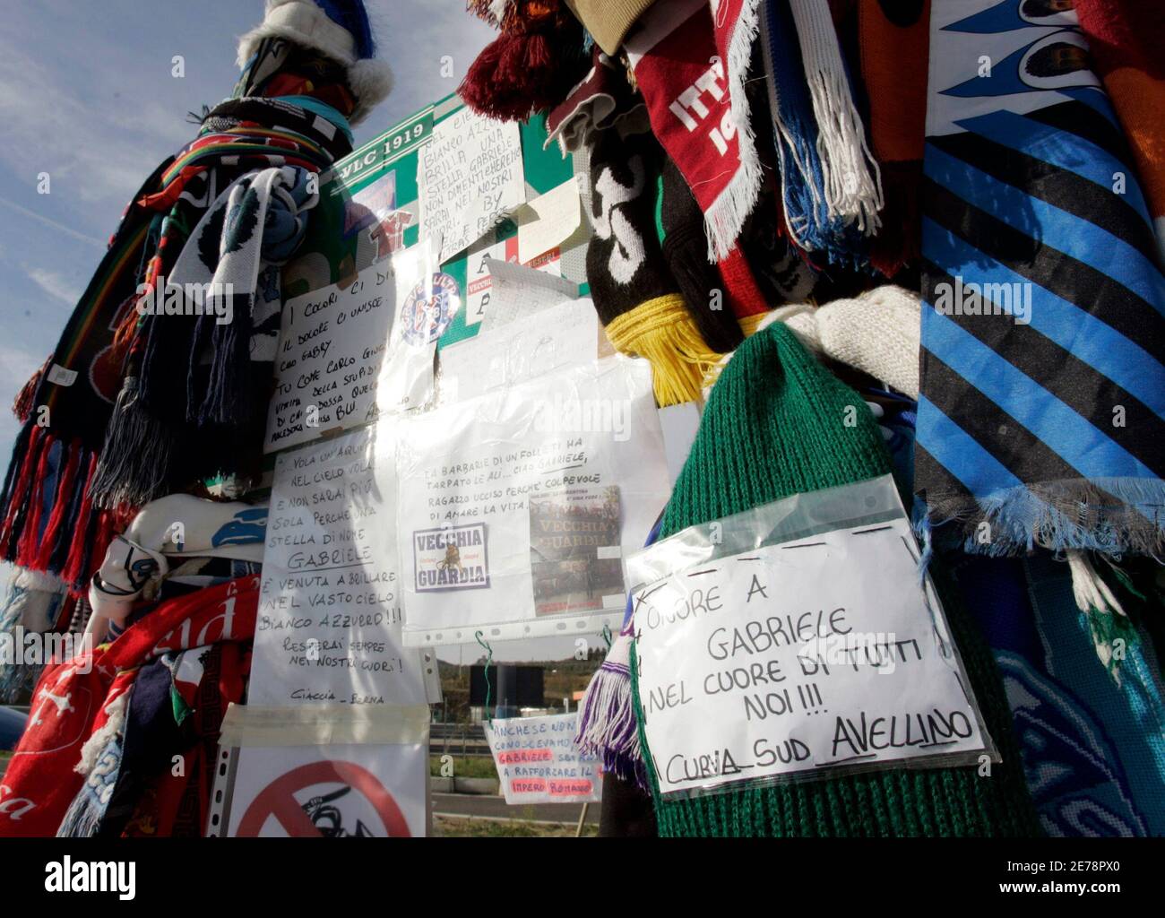 Un panneau routier est recouvert de foulards de différentes équipes de  football comme un sanctuaire de fortune à l'fan du Latium Gabriele Sandri,  qui a été abattu le week-end par un policier