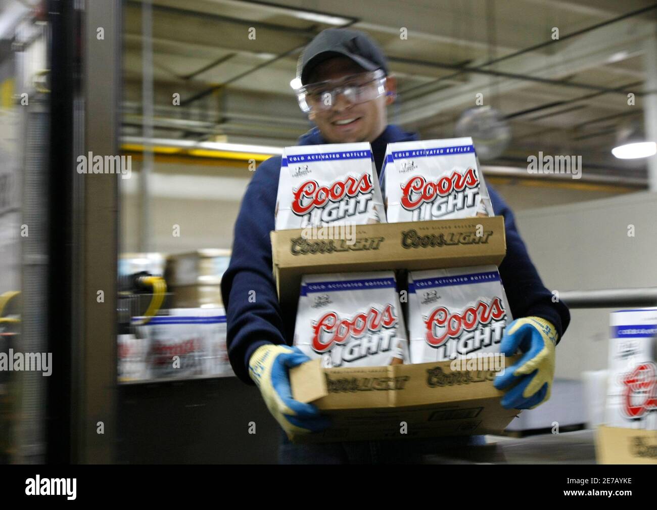 Christian Aguilar, a bottle line packaging production worker at the Coors  brewery in Golden, Colorado takes Coors Light cases off the line for label  inspection October 16, 2007. Brewers SABMiller and Molson