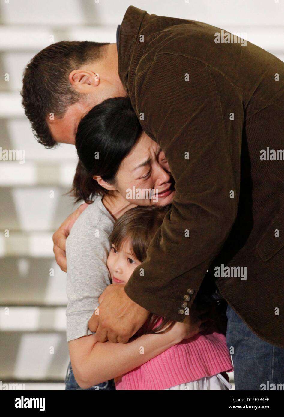Freed . journalist Euna Lee (C) is embraced by her husband Michael  Saldate (top) and daughter Hana Saldate after arriving with Laura Ling and  former President Bill Clinton in Burbank, California August