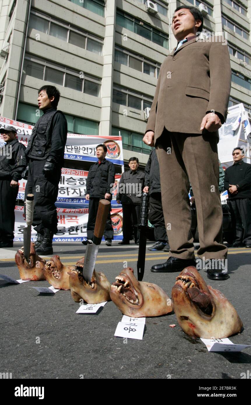 Former spy soldiers, who were trained to infiltrate North Korea, sing the South Korea national anthem while standing behind a row of five dog heads during a protest celebrating the anniversary of Former spy soldiers, who were trained to infiltrate North Korea, sing the South Korea national anthem while standing behind a row of five dog heads during a protest celebrating the anniversary of