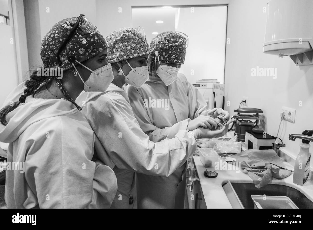 Médecins examinant un moule dentaire. Trois femmes médecins. Noir et blanc. Concept de santé dentaire. Bruit. Banque D'Images