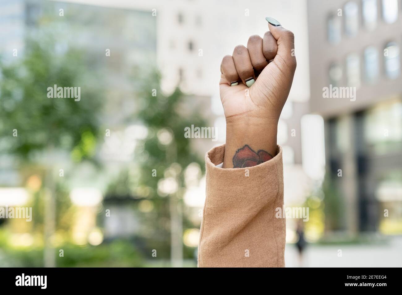 Gros plan de la femme avec tatouage sur son poignet la levant mains en ville Banque D'Images