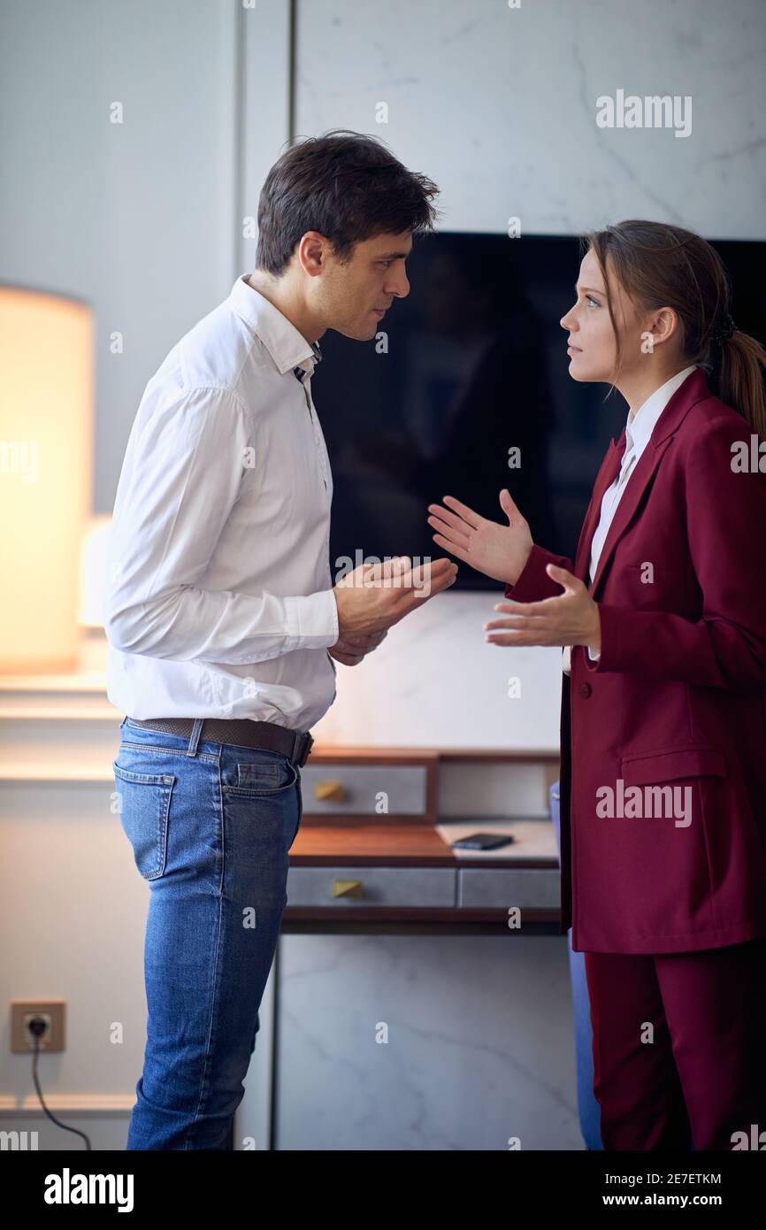 Un jeune couple se disputant dans la chambre d'hôtel lors de son voyage d'affaires pour une nouvelle affaire. Hôtel, affaires, personnes Banque D'Images