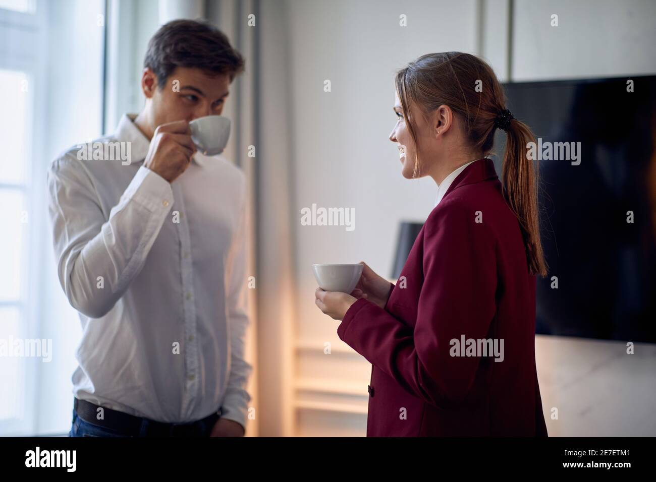 Chambre de jeune couple prenant un café à l'hôtel lors de leur voyage d'affaires pour une nouvelle offre. Hôtel, affaires, personnes Banque D'Images