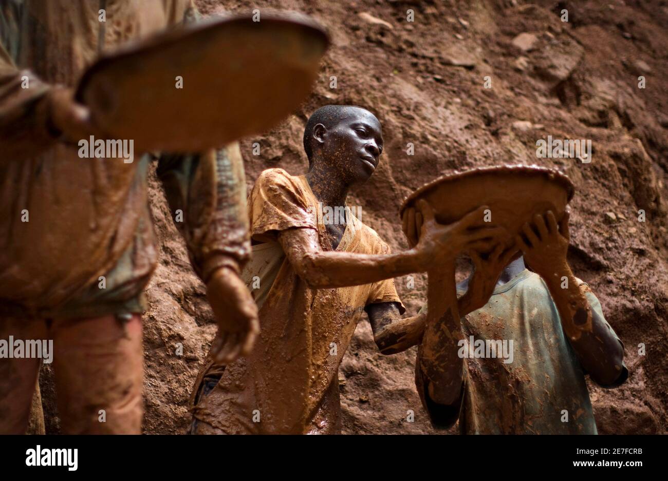 Gold miners form a human chain while digging an open pit at the Chudja mine in the Kilomoto concession near the village of Kobu, 100 km (62 miles) from Bunia in north-eastern Gold miners form a human chain while digging an open pit at the Chudja mine in the Kilomoto concession near the village of Kobu, 100 km (62 miles) from Bunia in north-eastern