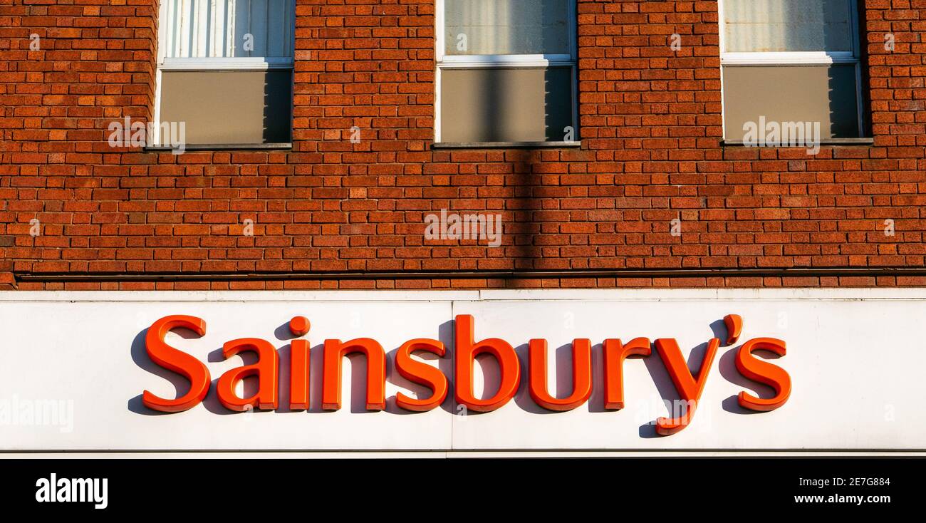 Logo et panneau de Sainsbury au-dessus de l'entrée du supermarché à Golders Green. Lettres orange sur fond blanc. Banque D'Images