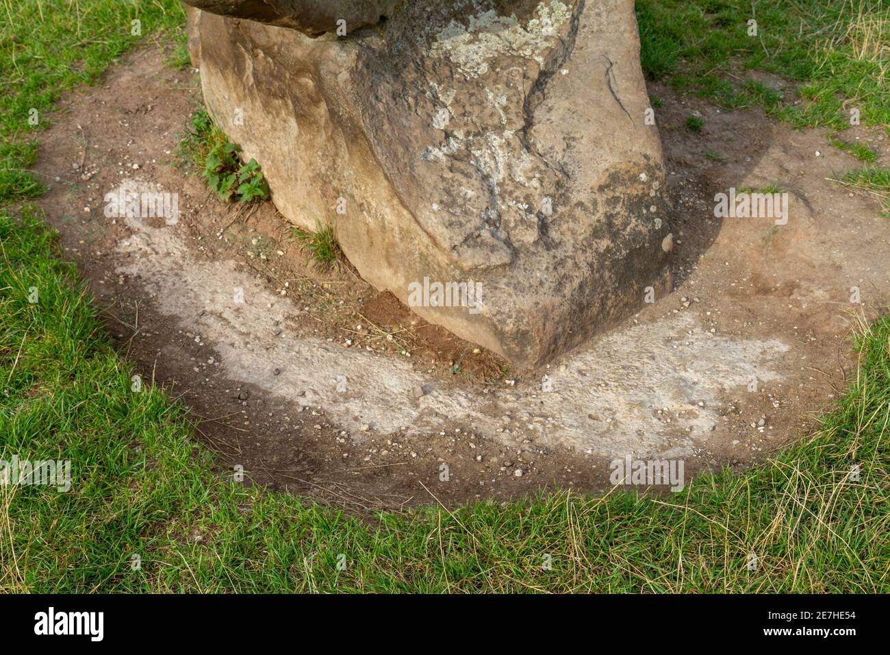 A exposé des fondations en béton à l'une des pierres du cercle extérieur du site de Avebury Henge & Stone Circles, Wiltshire, Angleterre. Banque D'Images