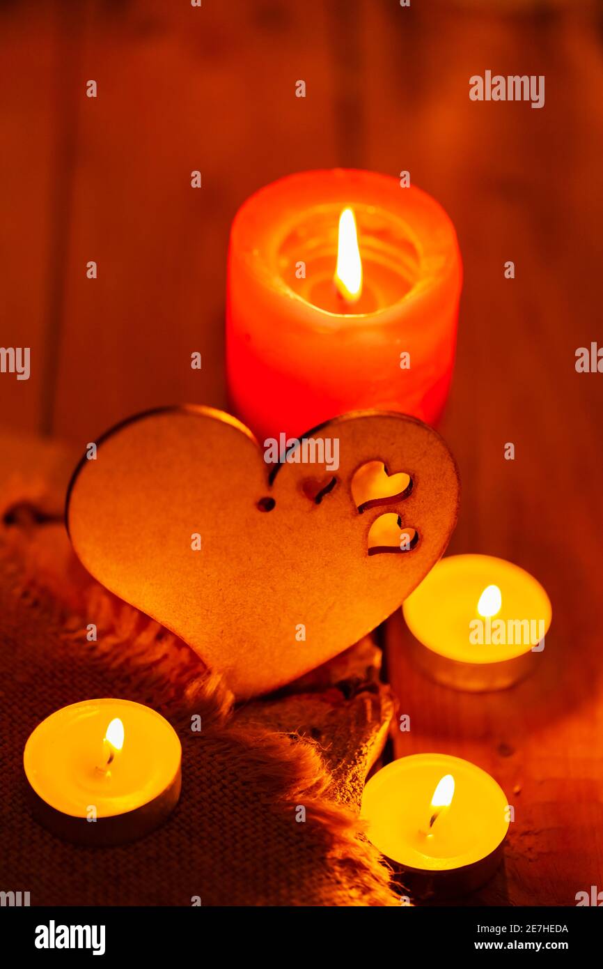 Coeur en bois et bougies sur toile de jute et planches en bois. Carte de  vœux de Saint-Valentin avec bougie et coeur sur fond flou. Histoire d'amour  conce Photo Stock - Alamy