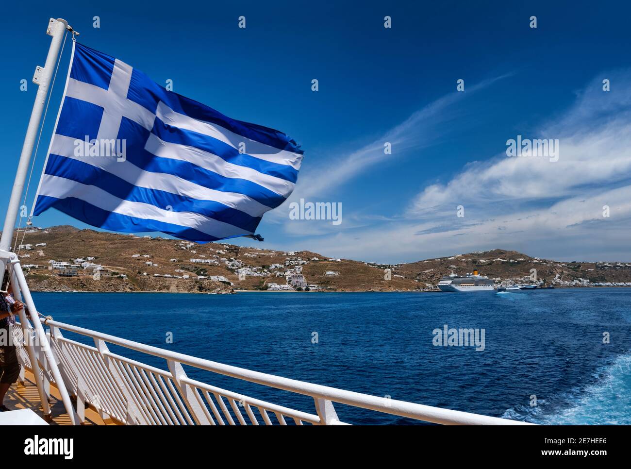 Drapeau grec agitant contre le paysage typique des îles grecques. Paquebots de croisière et ferries, jour d'été. Saut sur l'île, aventure, exploration de la mer Méditerranée. Banque D'Images