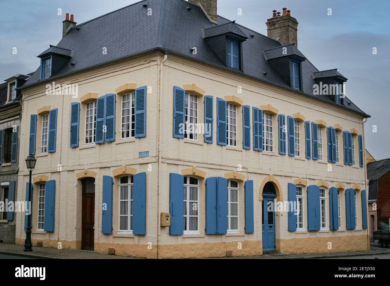 Bâtiment provincial français avec volets bleus distinctifs et toit en ardoise Banque D'Images