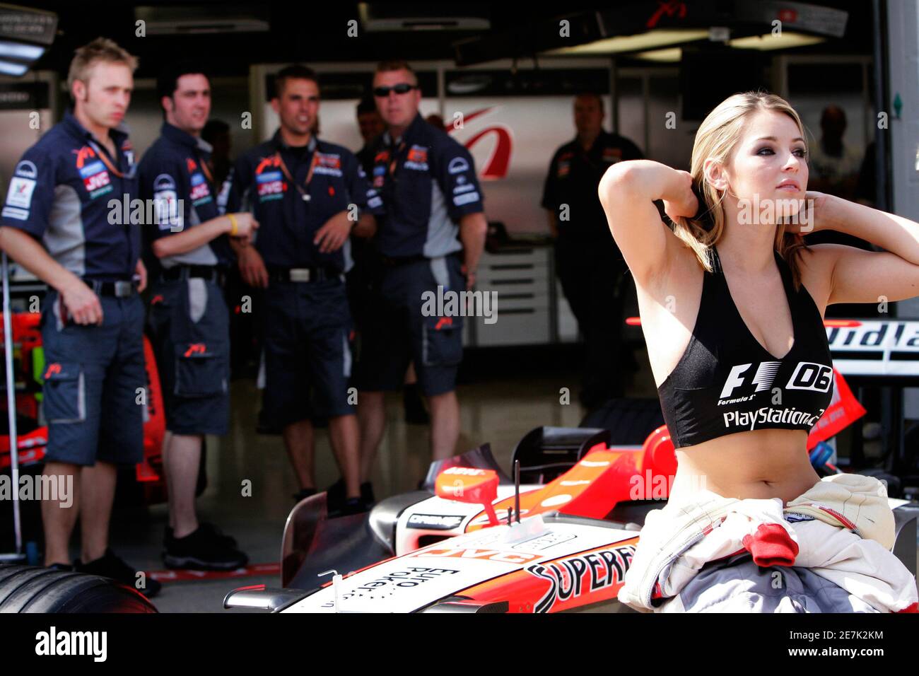 British model Keeley Hazell, the new U.K. female face of the Playstation  'Formula One 2006' computer game, sits in the Midland F1 Racing Team garage  for a photocall before the British Grand
