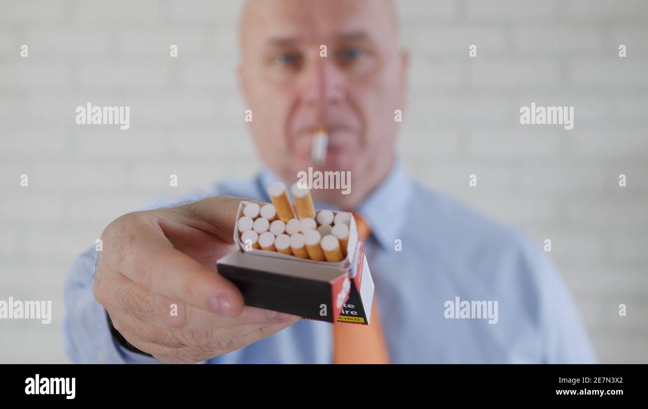 Image avec un homme d'affaires fumant une cigarette. La fumée et la dépendance à la nicotine causent de graves problèmes de santé. Banque D'Images