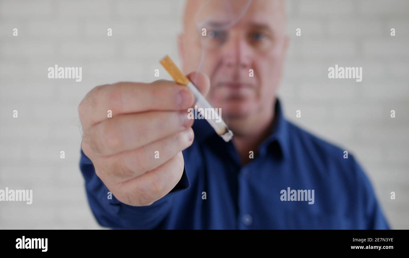 Image avec un homme d'affaires fumant une cigarette. La fumée et la dépendance à la nicotine causent de graves problèmes de santé. Banque D'Images