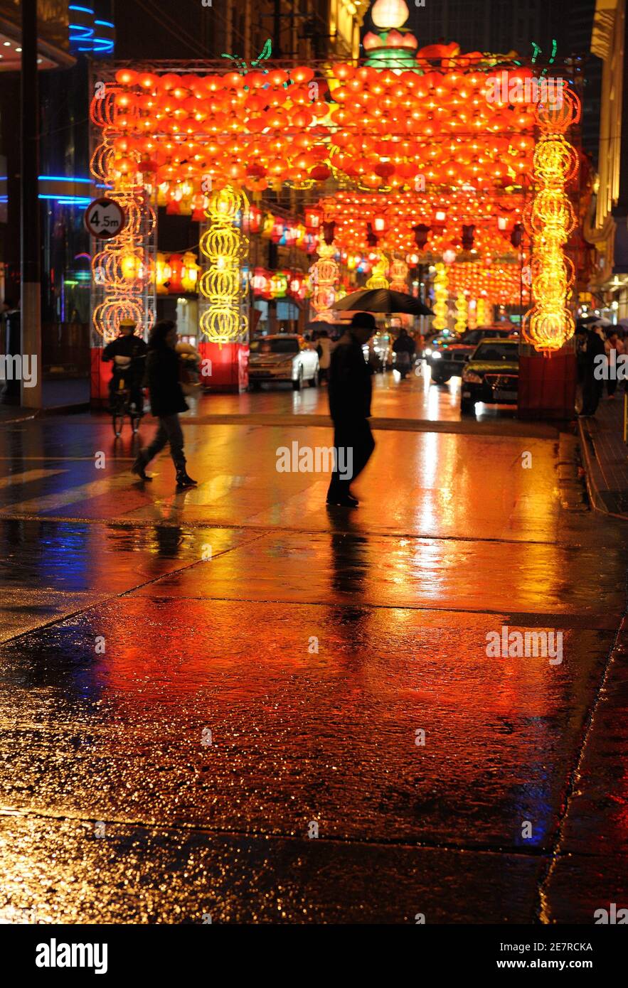 Les Chinois marchent à la nuit des pluies dans la rue décorée pour Nouvel an chinois Banque D'Images