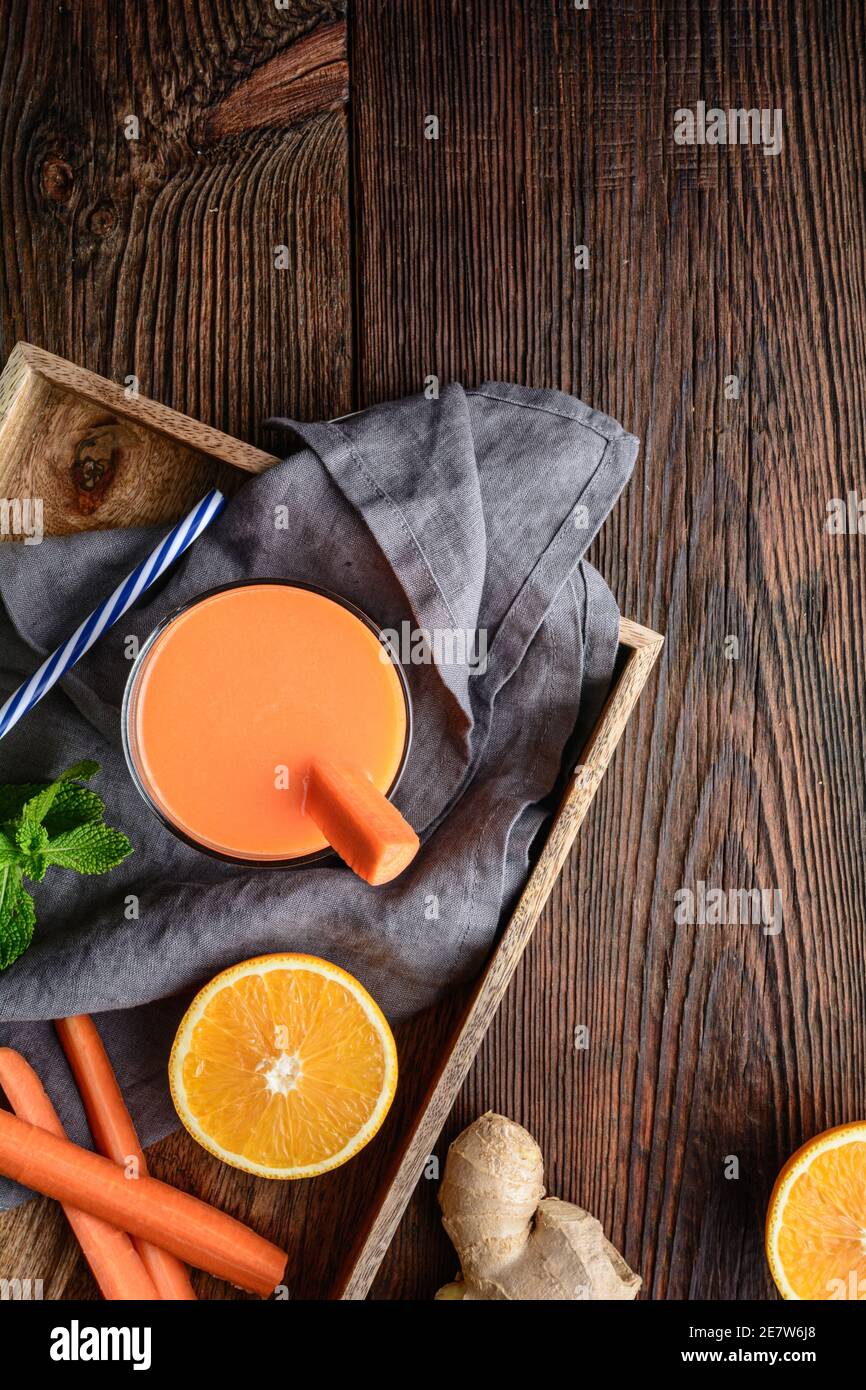 Boisson nourrissante pour le petit déjeuner, carottes fraîches, jus d'orange et de gingembre sur fond de bois rustique Banque D'Images