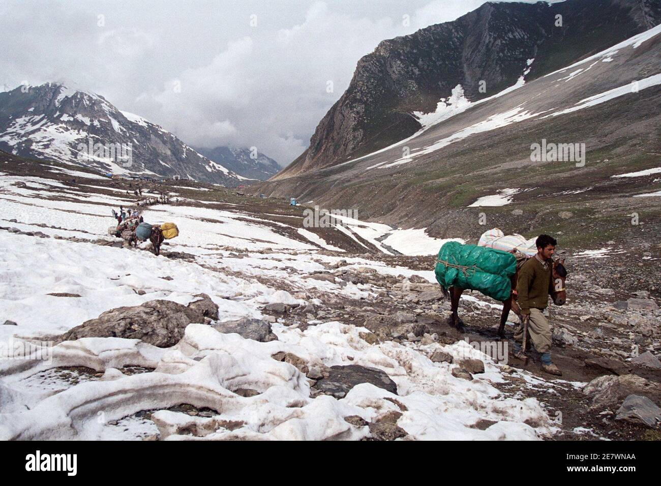 PHOTO TAKEN 12JUN06- Kashmiri horsemen, who transport Hindu pilgrims on  their pilgrimage to the Amarnath shrine, walk over a glacier near Sheshnag,  130 km (81 miles) southeast of [Srinagar], June 12, 2006.