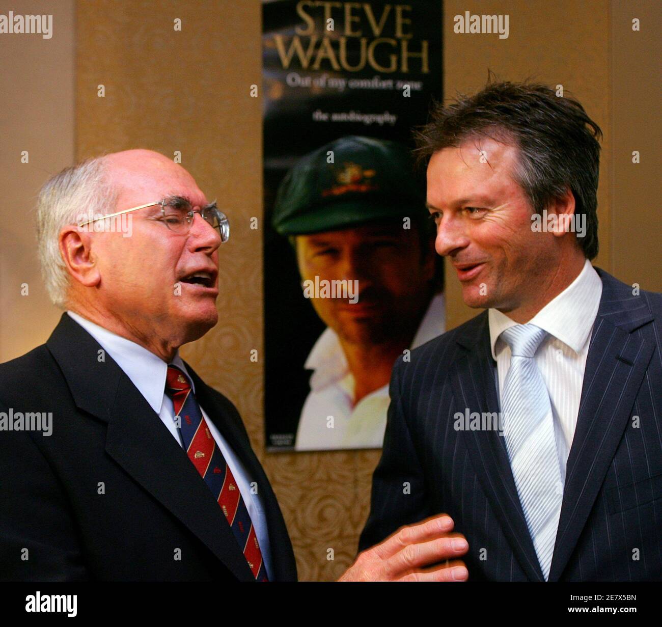 Le Premier ministre australien John Howard (L) s'adresse à l'ancien capitaine de l'équipe australienne de cricket Steve Waugh, avant que Howard ne lance officiellement l'autobiographie de Waugh à Sydney le 23 octobre 2005. Waugh, le capitaine australien du cricket Test de 1999 à 2004, a écrit le livre intitulé « Out of My Comfort zone », dans lequel il révèle des informations sur la vie sur le terrain et en dehors pendant qu'il dirigeait une équipe dominante. REUTERS/will Burgess Banque D'Images