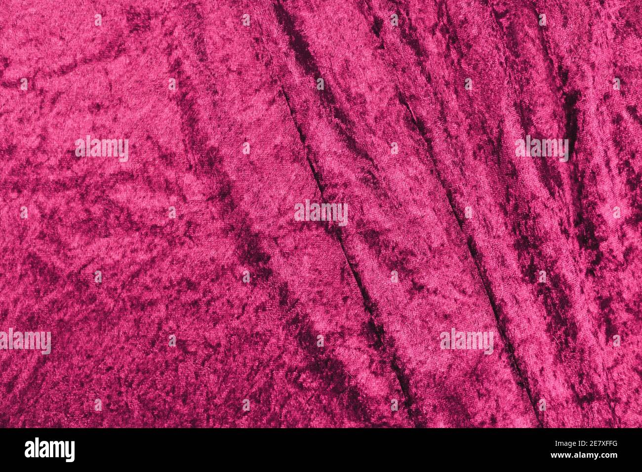 Texture textile en velours de panne rose foncé avec plis Banque D'Images
