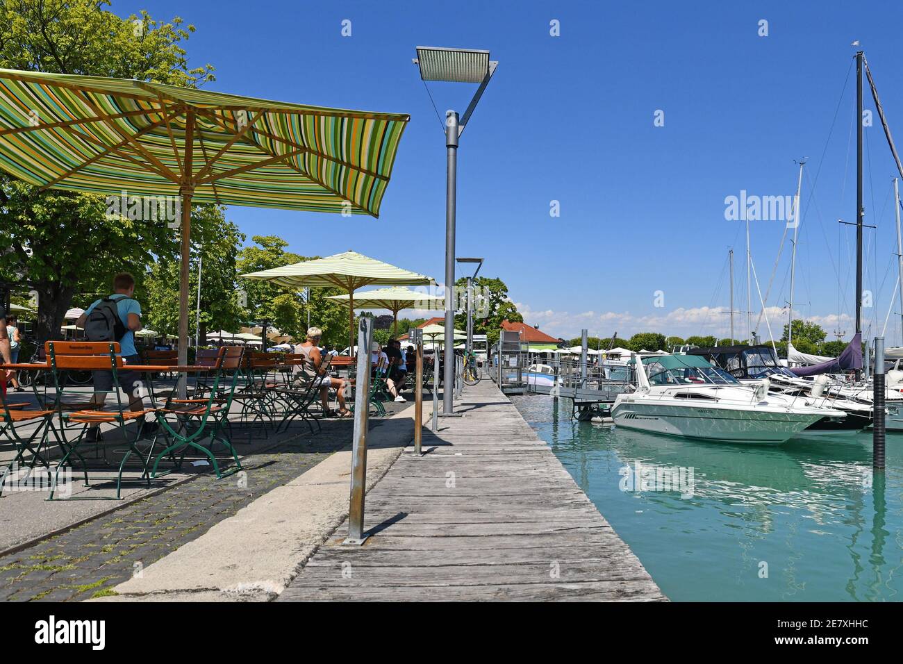 Konstanz, Allemagne - juillet 2020 : cafés extérieurs avec parasols et bateaux à la marina de yacht au port du lac de Constance le jour d'été ensoleillé Banque D'Images