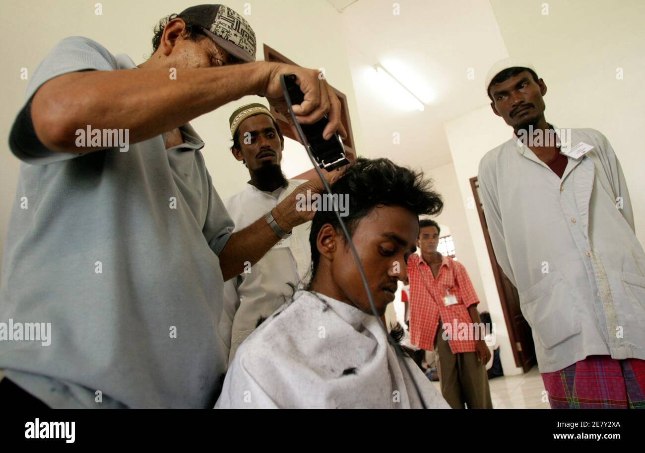 One of the Rohingya boat people, rescued off the coast of Indonesia's Aceh  province, has his hair cut by an Indonesian official at a temporary shelter  in Idi Rayeuk February 4, 2009.
