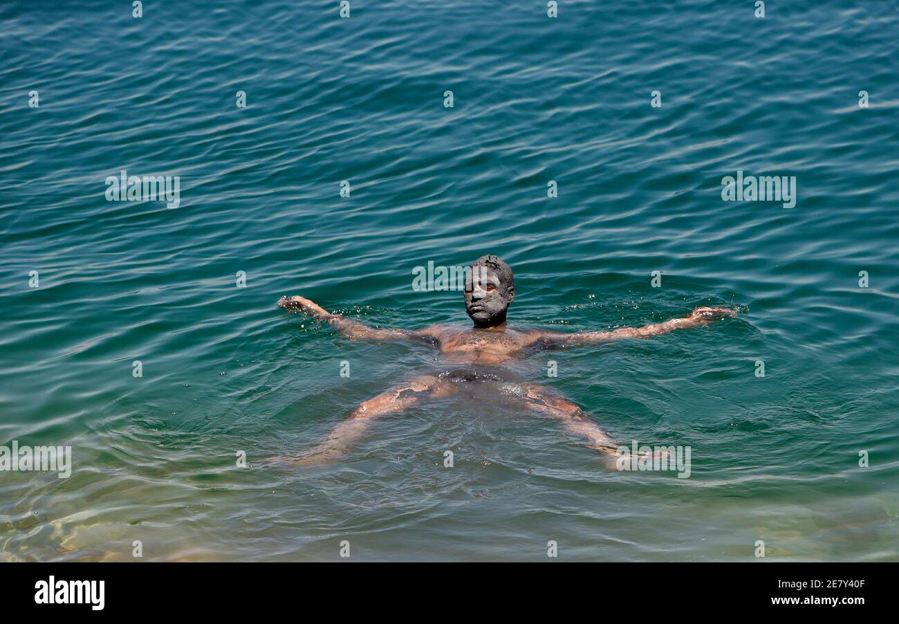Un homme baigné dans la mer Morte près de Kibbutz Ein Gedi le 28 juin 2009. La mer Morte sera éliminée la semaine prochaine d'un concours visant à choisir les sept merveilles naturelles du monde, en raison d'un boycott palestinien sur la participation d'un conseil des colons israéliens. REUTERS/Ammar Awad (VOYAGE POLITIQUE EN ISRAËL) Banque D'Images