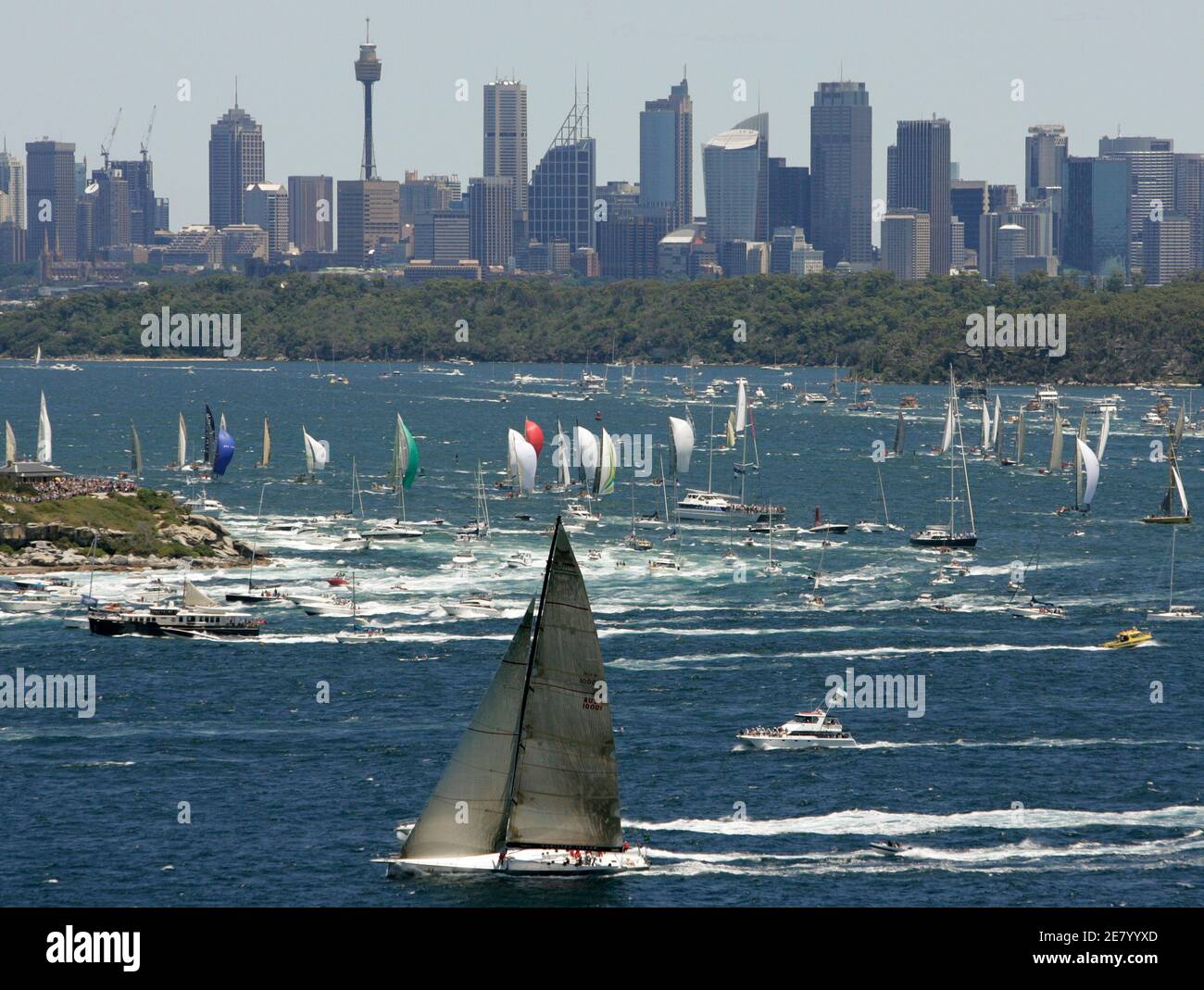Wild Oats XI passe devant les gratte-ciel de la ville car elle est le premier yacht à atteindre les Sydney Heads après le début de la course annuelle de yacht Sydney-Hobart le 26 décembre 2006. REUTERS/will Burgess (AUSTRALIE) Banque D'Images