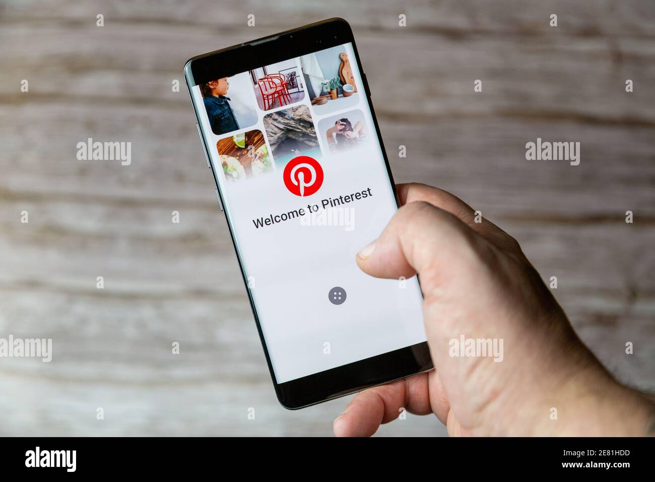 Une main tenant un téléphone portable ou un téléphone cellulaire avec L'application Pinterest s'ouvre à l'écran Banque D'Images