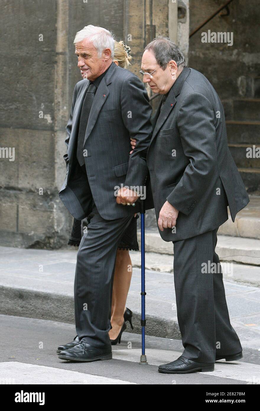 Robert Hossein aide Jean-paul Belmondo à quitter la messe funéraire de  l'acteur français Jean-Claude Brialy tenu à l'église 'Saint-Louis en Ile' à  Paris, France, le 4 juin 2007. Photo par ABACAPRESS.COM Photo
