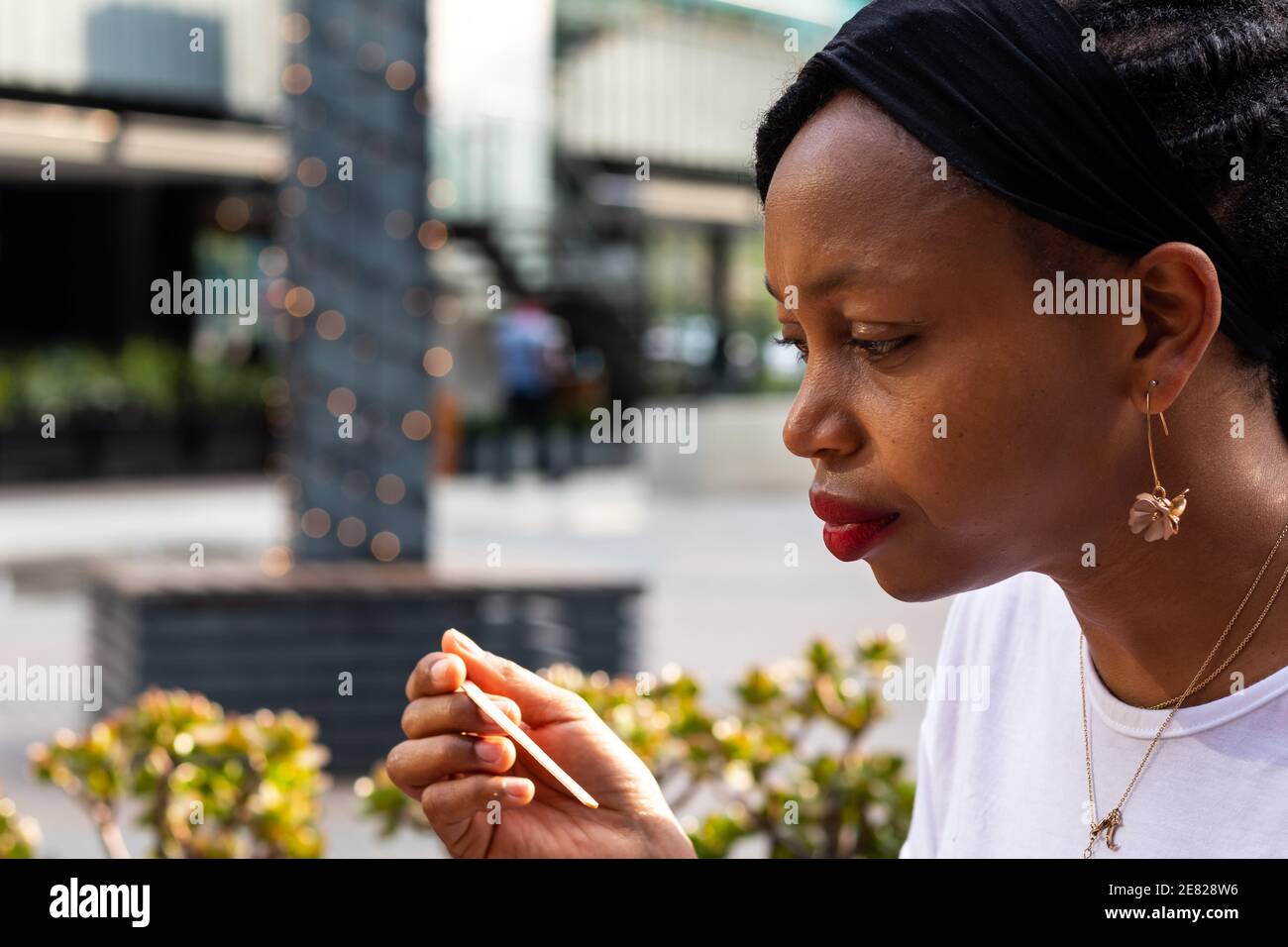 Gros plan sur le profil de la femme africaine pensive à la regarder stylo ou cuillère Banque D'Images